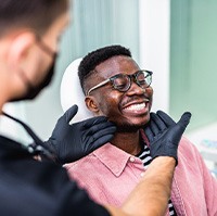 Dentist looking at patient's smile in treatment room